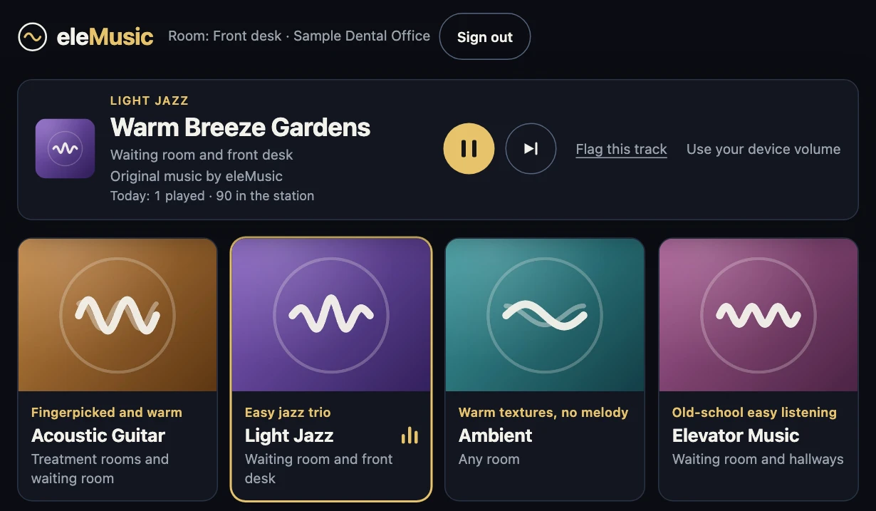 The same Front desk tablet playing Light Jazz. A now-playing card shows the station's artwork, the track title Warm Breeze Gardens, the line Original music by eleMusic, a Pause button, a Next button, a Flag this track link and the hint Use your device volume. Below it, the Light Jazz tile is outlined in gold.